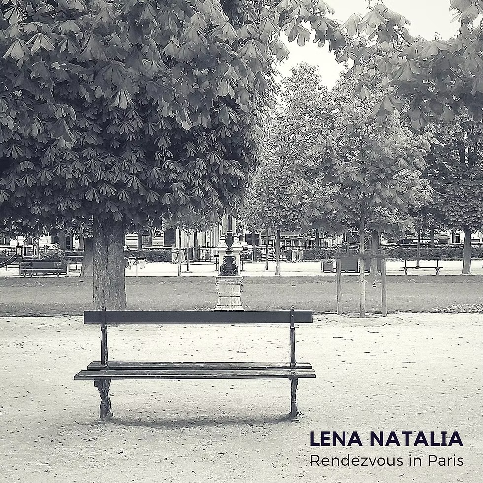 Empty park bench facing symmetrical trees in a quiet European square.
